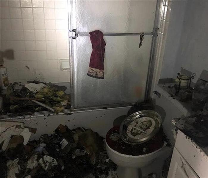 The bathroom is covered in damaged content following an electrical fire
